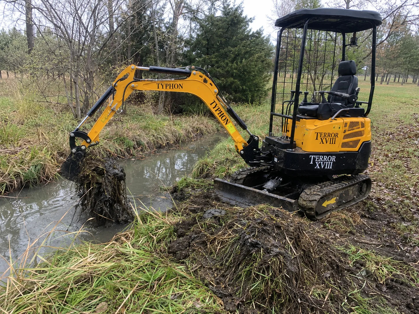 TYPHON TERROR XVIII mini excavator cleaning a ditch and improving water flow